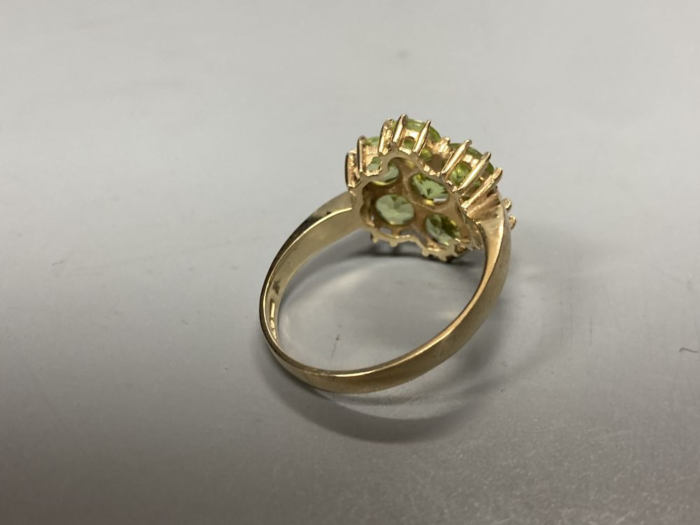 A modern 9ct gold and seven stone peridot cluster ring, size P, gross 3.4 grams.